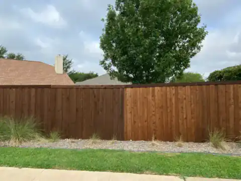 Completed cedar privacy fence beside a green lawn