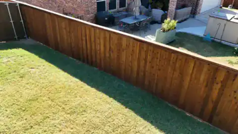 Cedar privacy fence spans the rear of a landscaped yard.