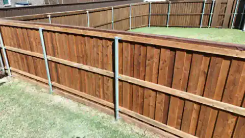 Close view of a cedar privacy fence with metal support posts.