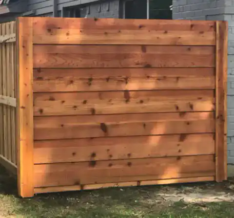 Close view of a cedar gate panel with black hardware.