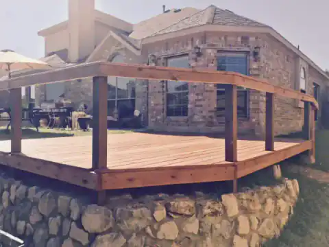 Raised octagonal cedar deck with wood railing overlooks the yard.