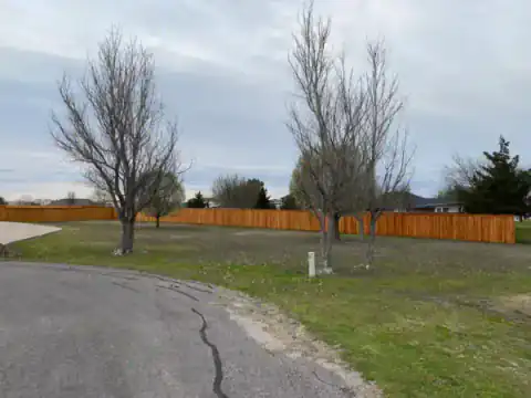Cedar fence follows a curved residential street.