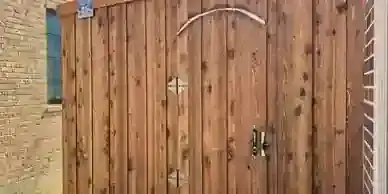 Cedar gate with an arched top closes a side passage.