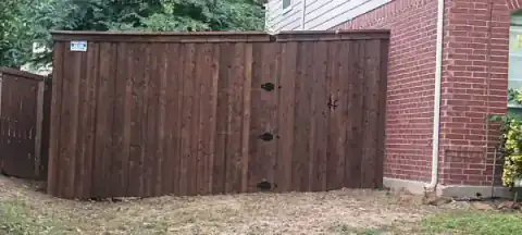 Cedar double gate closes the side of a brick home.