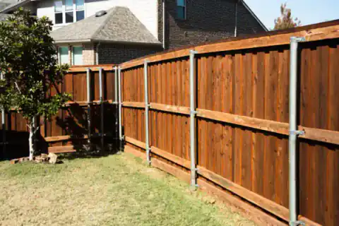Cedar gate and privacy fence enclose a backyard.