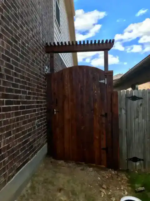 Cedar gate closes a narrow passage between two homes.