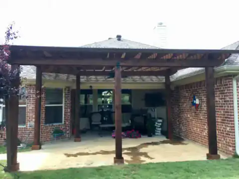 Covered outdoor patio with a wood structure and seating area