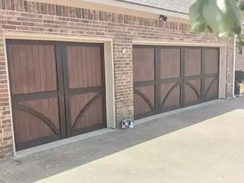 Brown carriage-style garage doors set into a brick facade.