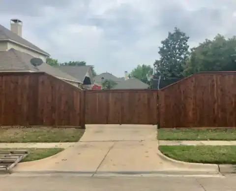 Cedar privacy fence follows a residential driveway.