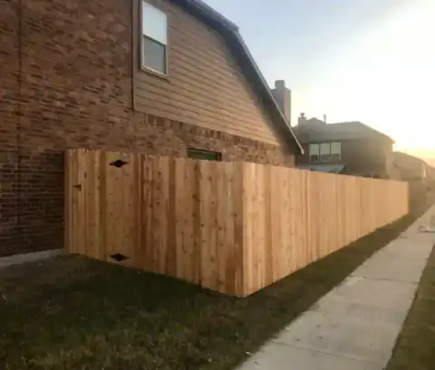 Cedar privacy fence encloses a narrow side lawn.