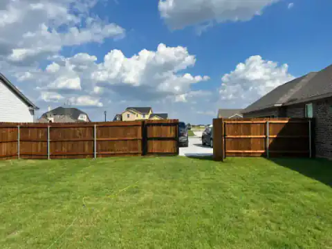 Cedar double gate closes a broad residential backyard.