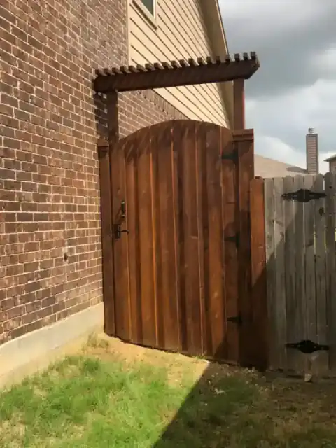 Cedar gate with a small pergola shelters a side entry.